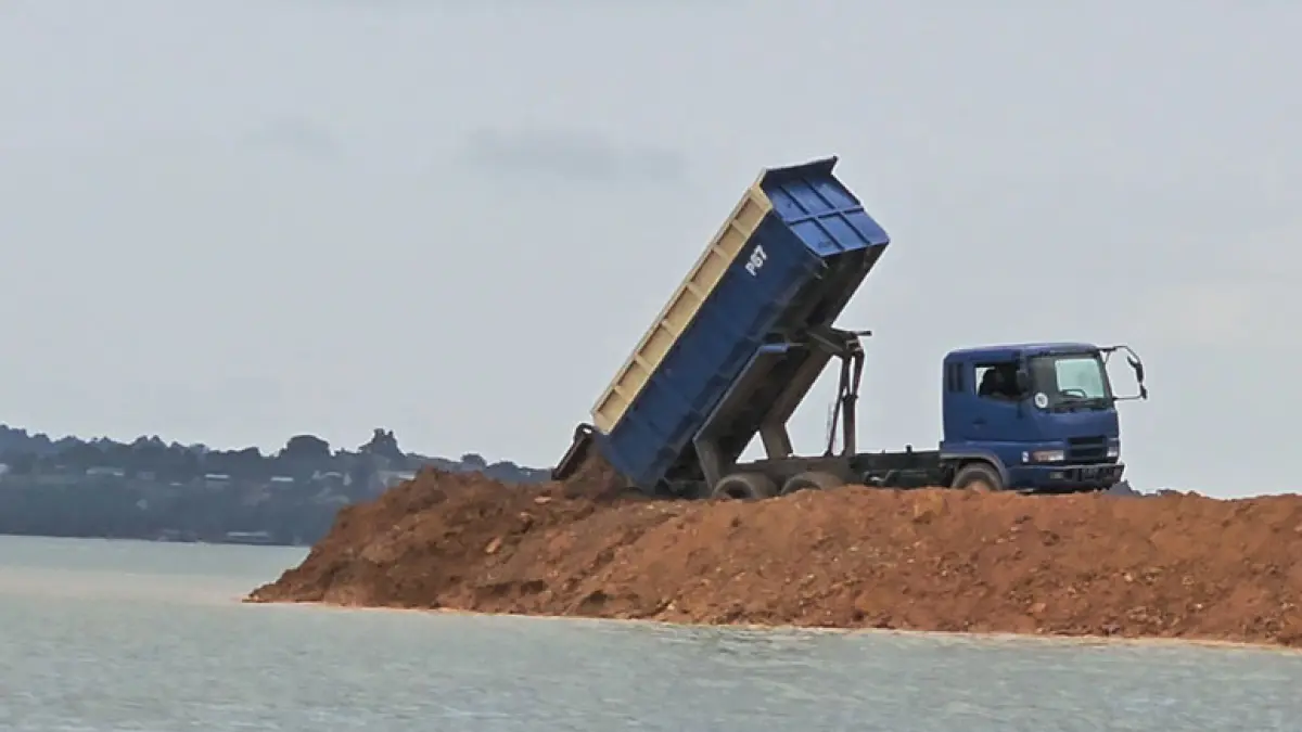 Kendaraan dump truck menurunkan material untuk mereklamasi salah satu pesisir Batam, beberapa waktu lalu. Foto: Akar Bhumi Indonesia Untuk Batam Pos