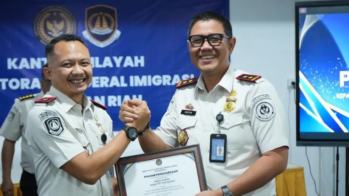 Kepala Kantor Imigrasi Kelas II TPI Tanjung Uban, Adi Hari Pianto (kiri) menerima penghargaan yang diserahkan Kepala Kantor Wilayah Ditjen Imigrasi Kepri, Guntur Sahat Hamonangan, baru-baru ini. F.Kiriman Reza untuk Batam Pos.