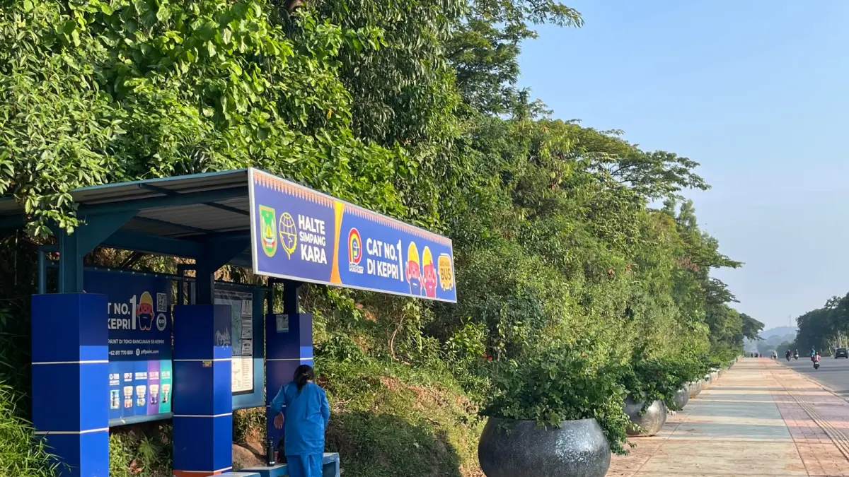 Seorang siswa menunggu Bus Trans Batam di Halte Simpang Kara yang telah dimanfaatkan sebagai media iklan salah satu produk cat, Jumat (7/8) sore. Foto: M. Sya’ban / Batam Pos 