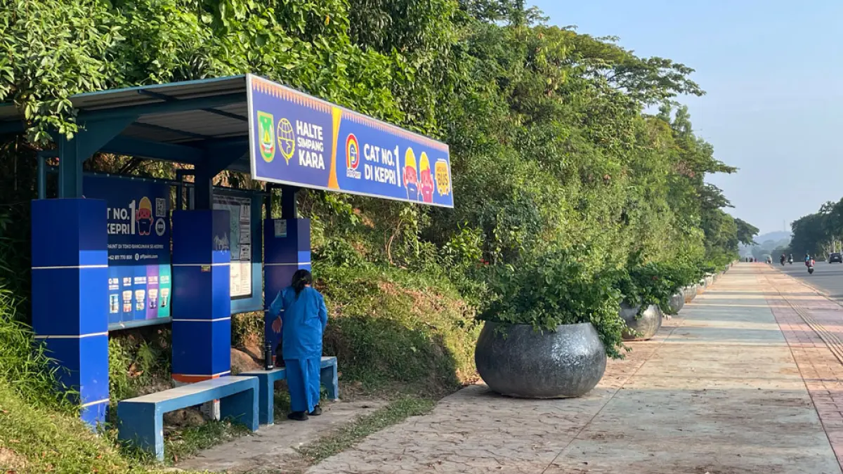 Seorang siswa menunggu Bus Trans Batam di Halte Simpang Kara yang telah dimanfaatkan sebagai media iklan salah satu produk cat, Jumat (7/8) sore. Foto: M SYA’BAN/BATAM POS