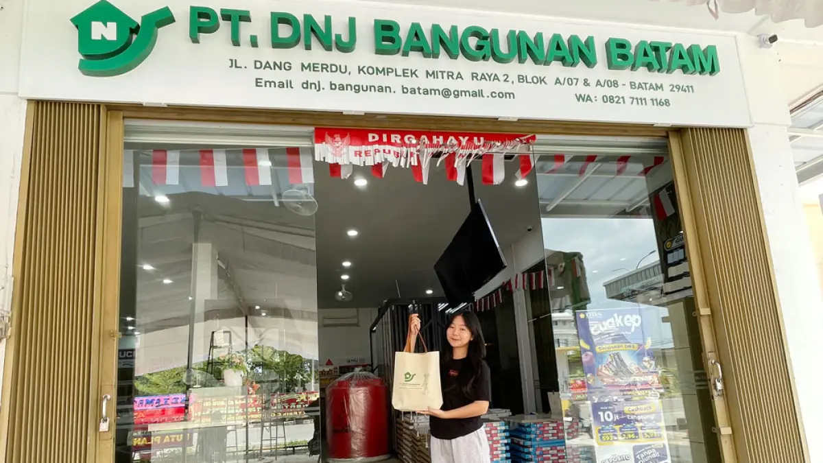 SALAH seorang pegawai PT DNJ Bangunan Batam menenteng tas belanja di depan toko, Minggu (9/8), sehari sebelum grand opening. Foto: M SYA’BAN/BATAM POS