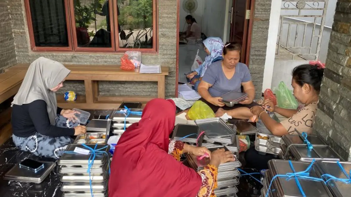 Kader Posyandu dan TPK BKKBN Kepri yang sedang melakukan pengepakan ulang MBG untuk para penerima manfaat kelompok 3B di lingkungan Pulau Buluh Batam, Kepri (30/7/2026). (ANTATA/Amandine Nadja) 