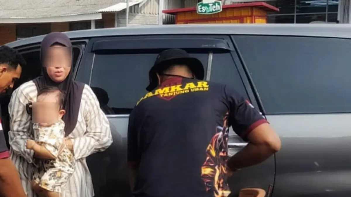 Petugas UPT Damkar Tanjunguban mengevakuasi seorang bayi berusia 1 tahun yang sempat terkunci di dalam mobil di Jalan Taman Sari, Tanjunguban, Bintan Utara, Kamis (13/8/2026). Proses evakuasi berlangsung sekitar 20 menit dan bayi berhasil diselamatkan dalam kondisi selamat meski sempat mengalami kepanasan di dalam kendaraan. F.Kiriman Panyodi untuk Batam Pos.
