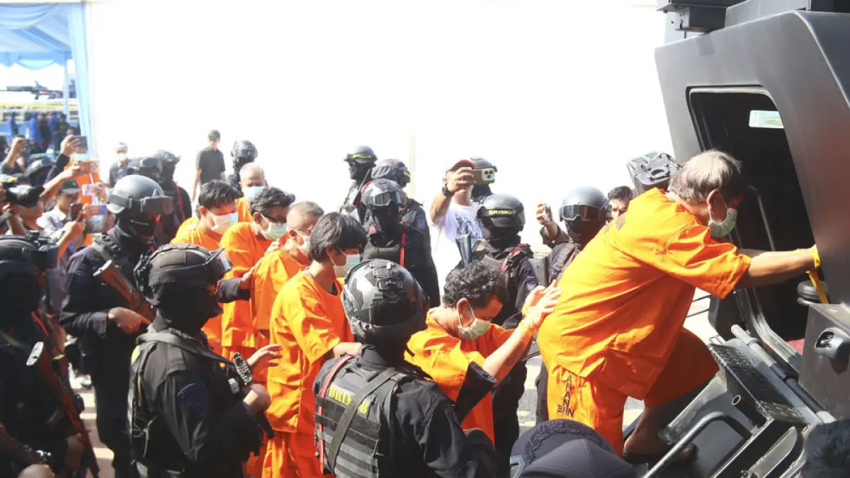 Petugas Kepolisian dan Bea Cukai menggiring para tersangka dalam kasus narkotika cair dan rokok ilegal usai konpers di Dermaga Bea Cukai di Tanjung Uncang, Jumat (21/8). Foto: Cecep Mulyana/Batam Pos
