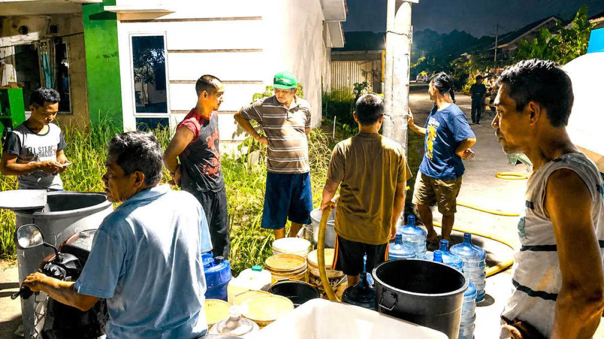 Warga salah satu perumahan di kawasan Seipelenggut, Dapur 12, Sagulung, mengantre untuk mendapatkan pasokan air bersih dari mobil tangki pada malam hari, beberapa waktu lalu. Foto: DOKUMENTASI BATAM POS