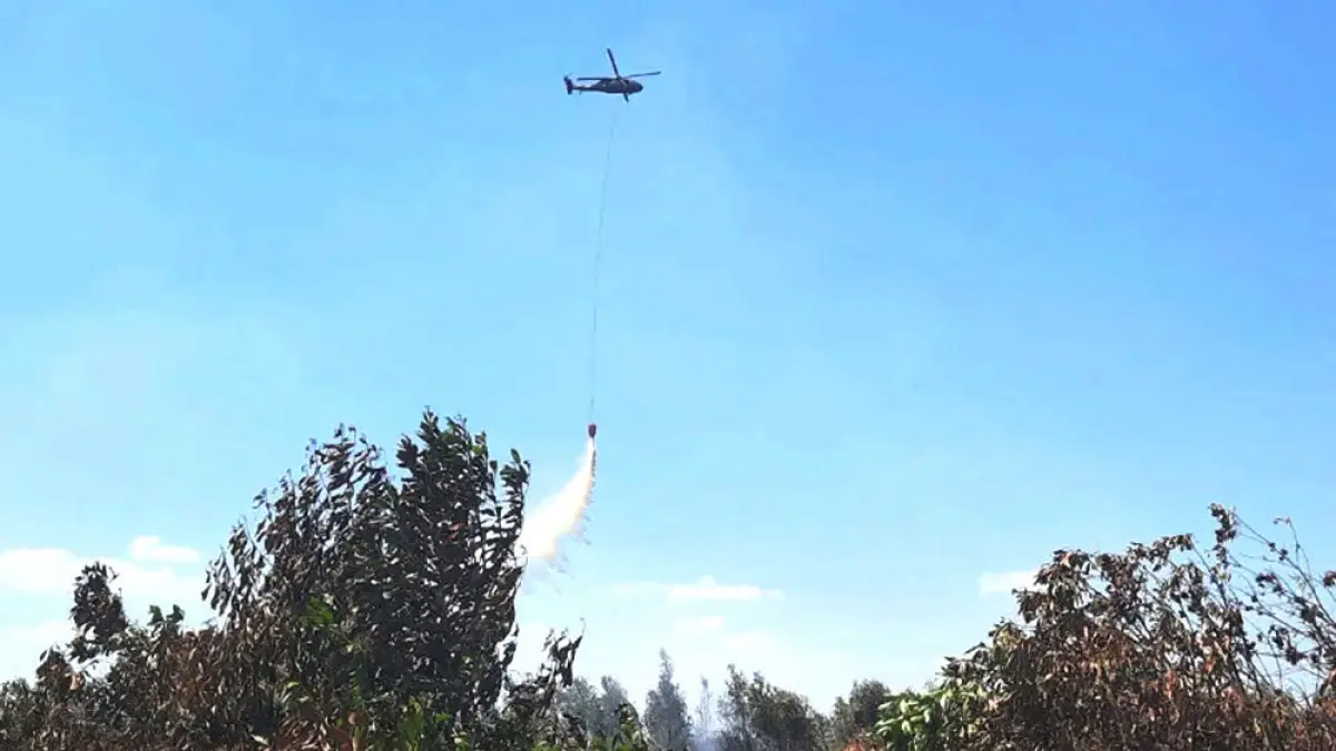 Helikopter water bombing bekerja memadamkan api yang membakar lahan di sekitar ring 1 Bandara Internasional Syamsudin Noor di Banjarbaru, Kalimantan Selatan, Selasa (25/8). Foto: ANTARA/Firman
