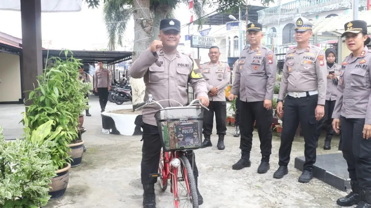 Kapolres Karimun, AKBP Yunita Stevani (kanan) menyaksikan Bhabinkamtibmas, Aipda Samson Tarigan, mencoba sepeda baru untuk kargo baca. Foto: dokumentasi Polres Karimun