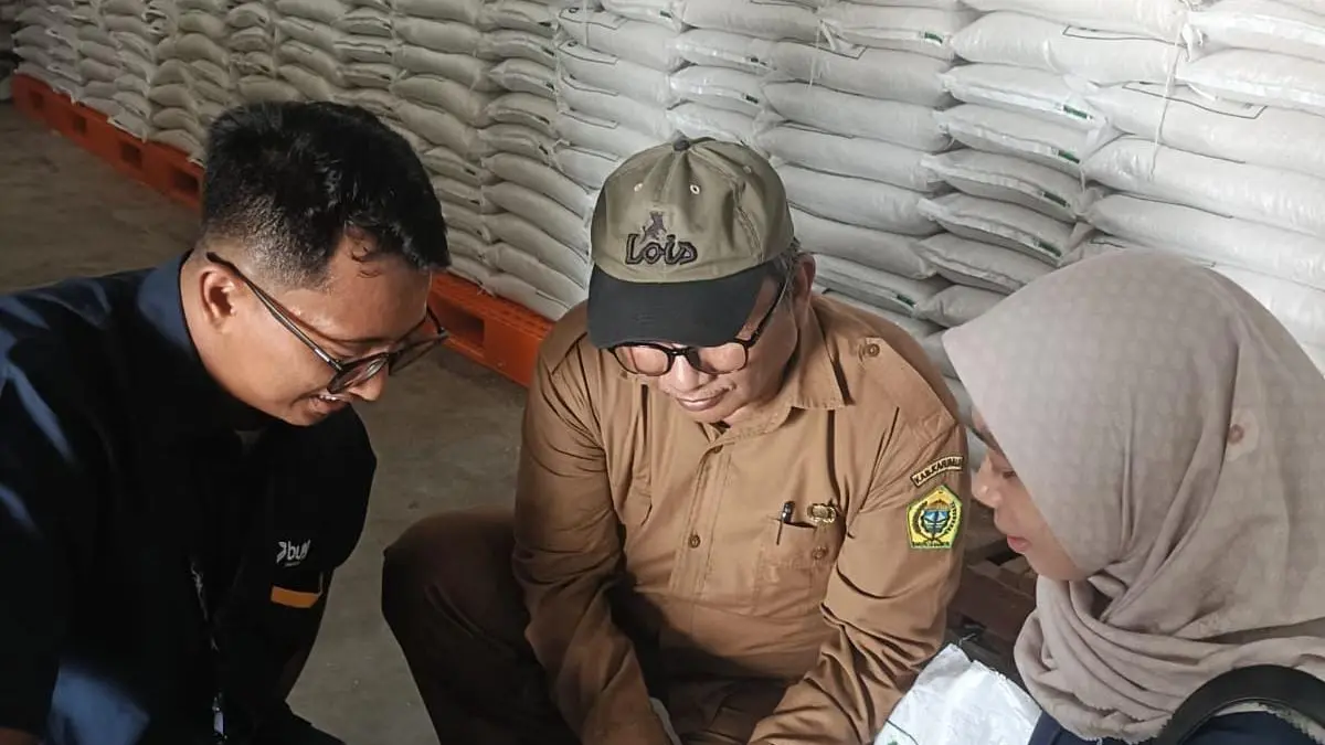 Kepala Dinas Pangan dan Pertanian Kabupaten Karimun, Sukrianto Jaya Putra sedang melakukan uji mutu dan pemeriksaan beras sebelum dibagikan ke penerima bantuan. 