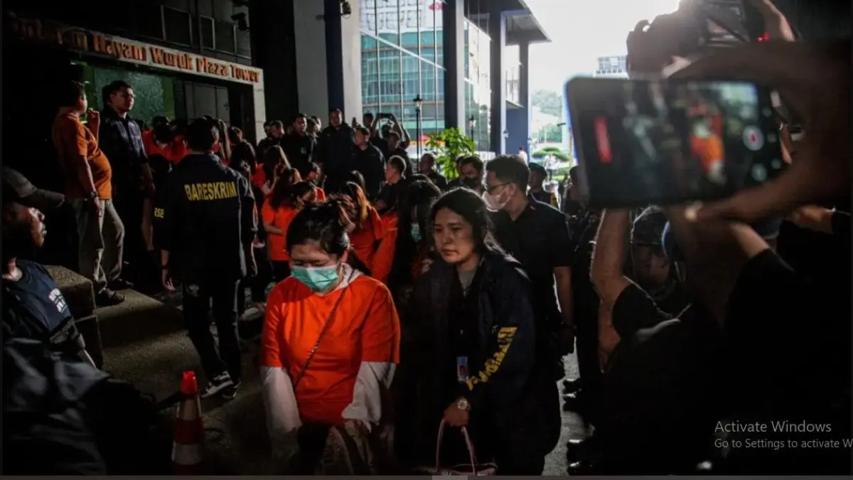 Sejumlah tersangka judi online (judol) dikawal ketat oleh aparat Kepolisian keluar dari Hayam Wuruk Tower, Jakarta. (Hanung Hambara/Jawa Pos)