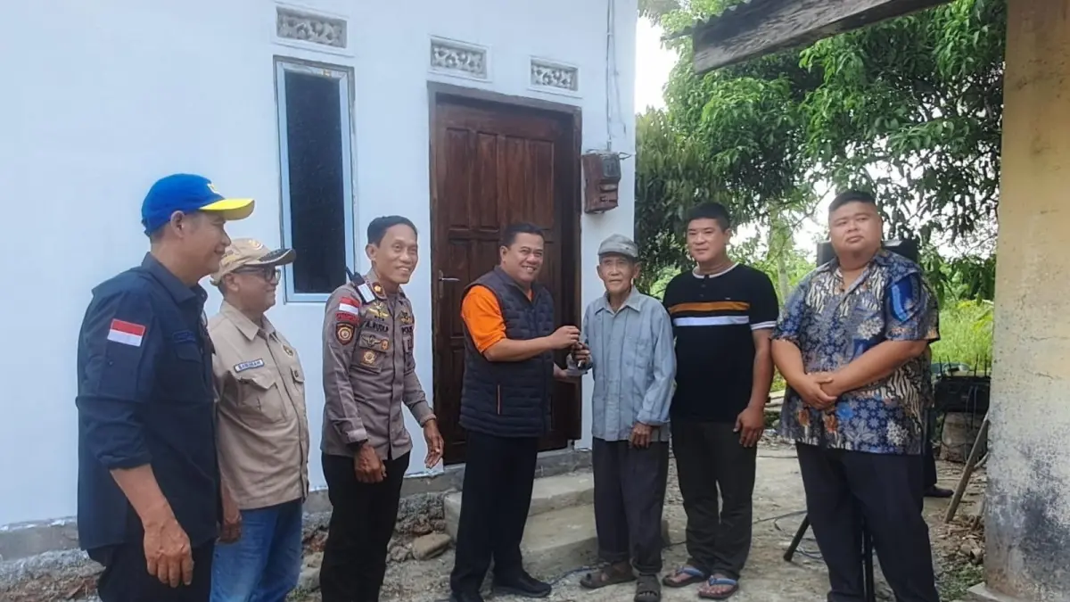 Sekda Bintan, Ronny Kartika menyerahkan kunci dari program bedah rumah PWI Bintan ke Kakek Kim Leng di Desa Sebong Lagoi, Kecamatan Teluk Sebong pada Jumat (4/9/2026). F.Slamet Nofasusanto/Batam Pos