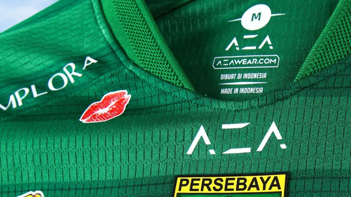 Jersey Persebaya Surabaya musim 2026/2027 hadirkan kecup bibir Implora, simbol ruang perempuan dan kultur sepak bola yang makin inklusif di Indonesia. Aksen kecup bibir di jersey Persebaya Surabaya musim 2026/2027 menjadi simbol kehadiran perempuan dalam kultur sepak bola yang semakin inklusif. (Dok. Persebaya)