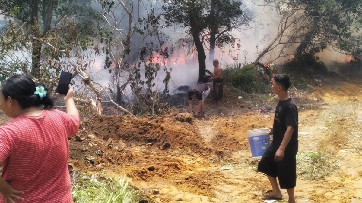 Warga berusaha memadamkan api di lahan yang terbakar di Jalan Pasar Baru, RT 004 RW 001 Desa Sebong Lagoi, Kecamatan Teluk Sebong, Senin (7/9/2026). F.Ariadi untuk Batam Pos