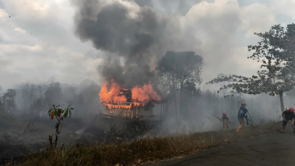 Kobaran api melalap sebuah pondok milik warga saat karhutla terjadi di Kelurahan Guntung Manggis, Kecamatan Landasan Ulin, Banjarbaru. Relawan berupaya mengendalikan api agar tidak semakin meluas. Foto: Riyad Dafhi Rizki/Mongabay Indonesia