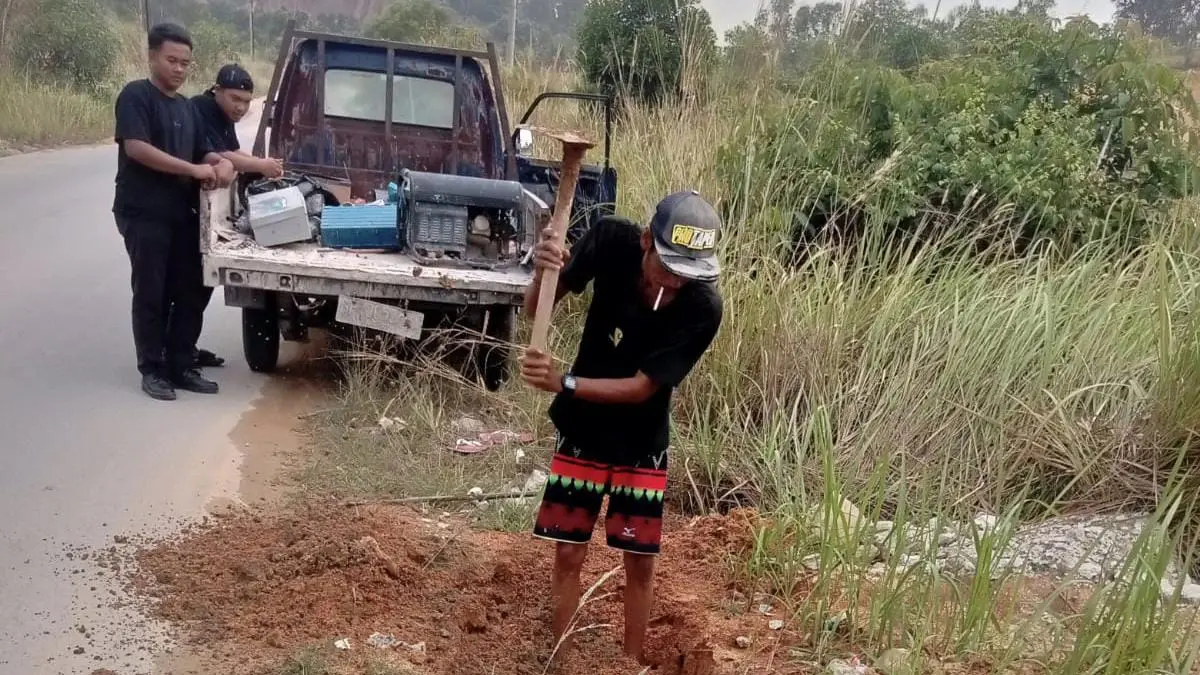 Seorang pekerja Perumda Tirta Mulia Karimun menggali lokasi untuk memperbaiki pipa yang mengalami kebocoran.