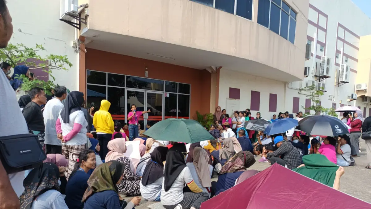 Pekerja PT Ghimli Indonesia bertahan di depan dan menggembok gerbang perusahaan, Selasa (29/9). F.Jamaluddin/Batam Pos