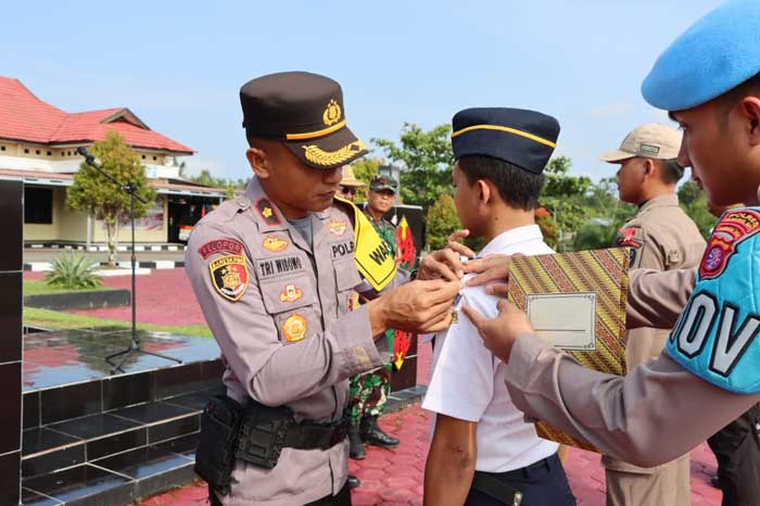 SEMATKAN: Wakapolres Gumas Kompol Tri Wibowo bersama Sekda Richard, saat menyematkan pita kepada perwakilan personel, sebagai tanda dimulainya Operasi Lilin Telabang tahun 2023, Kamis (21/12).