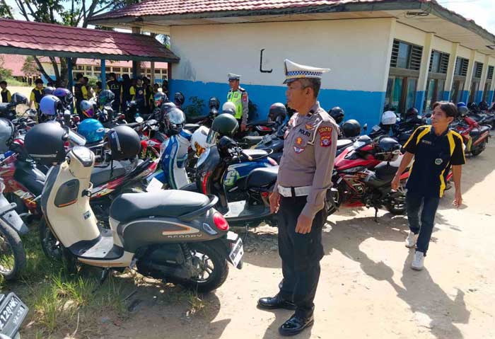 PERIKSA: Anggota Satlantas Polres Gumas memeriksa kendaraan roda dua milik para pelajar dan guru di SMPN 1 Kurun, Jumat (12/1).&nbsp;