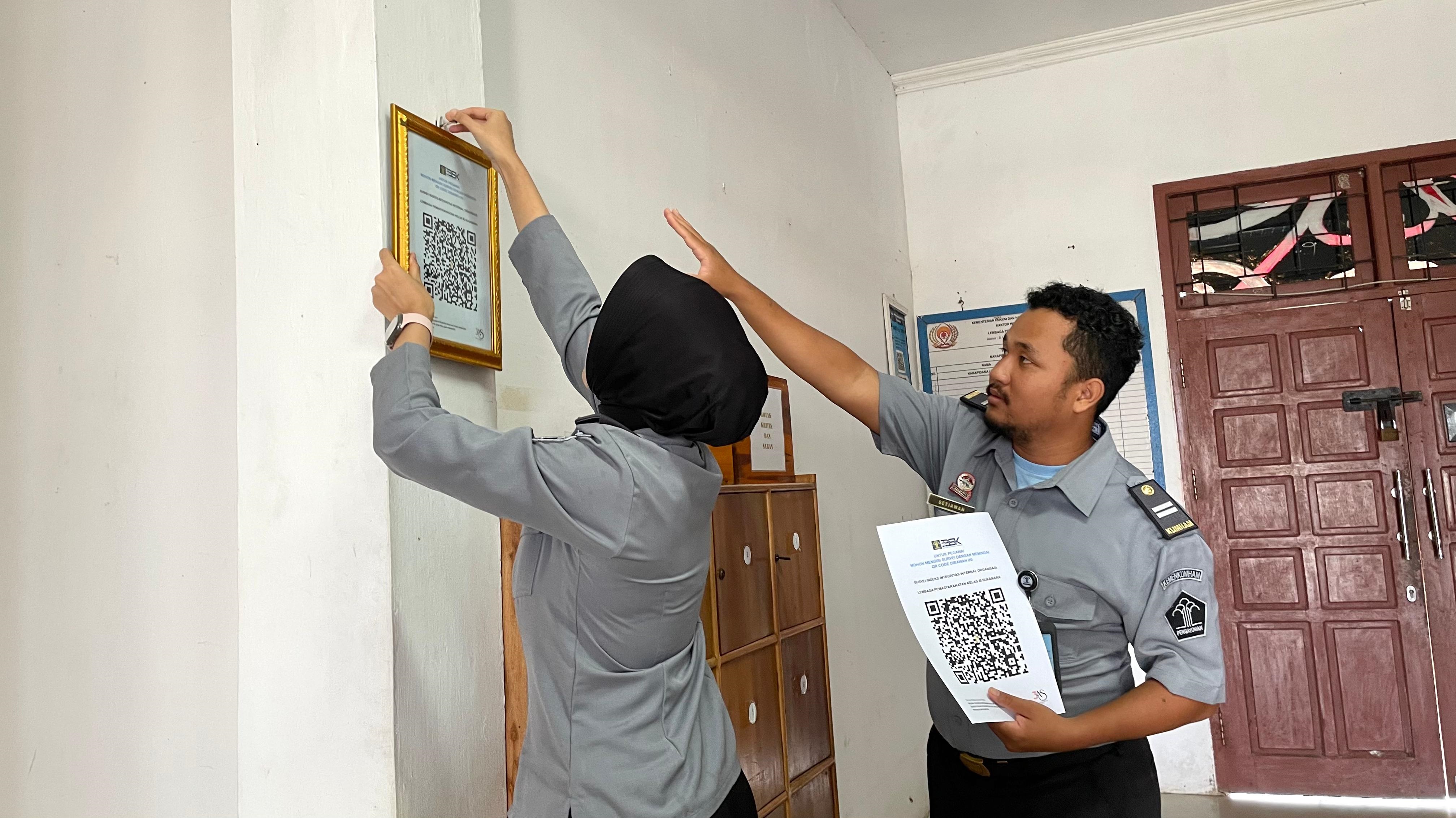 SURVEI: Petugas memasang barcode aplikasi survey pelayanan di Lapas Sukamara.