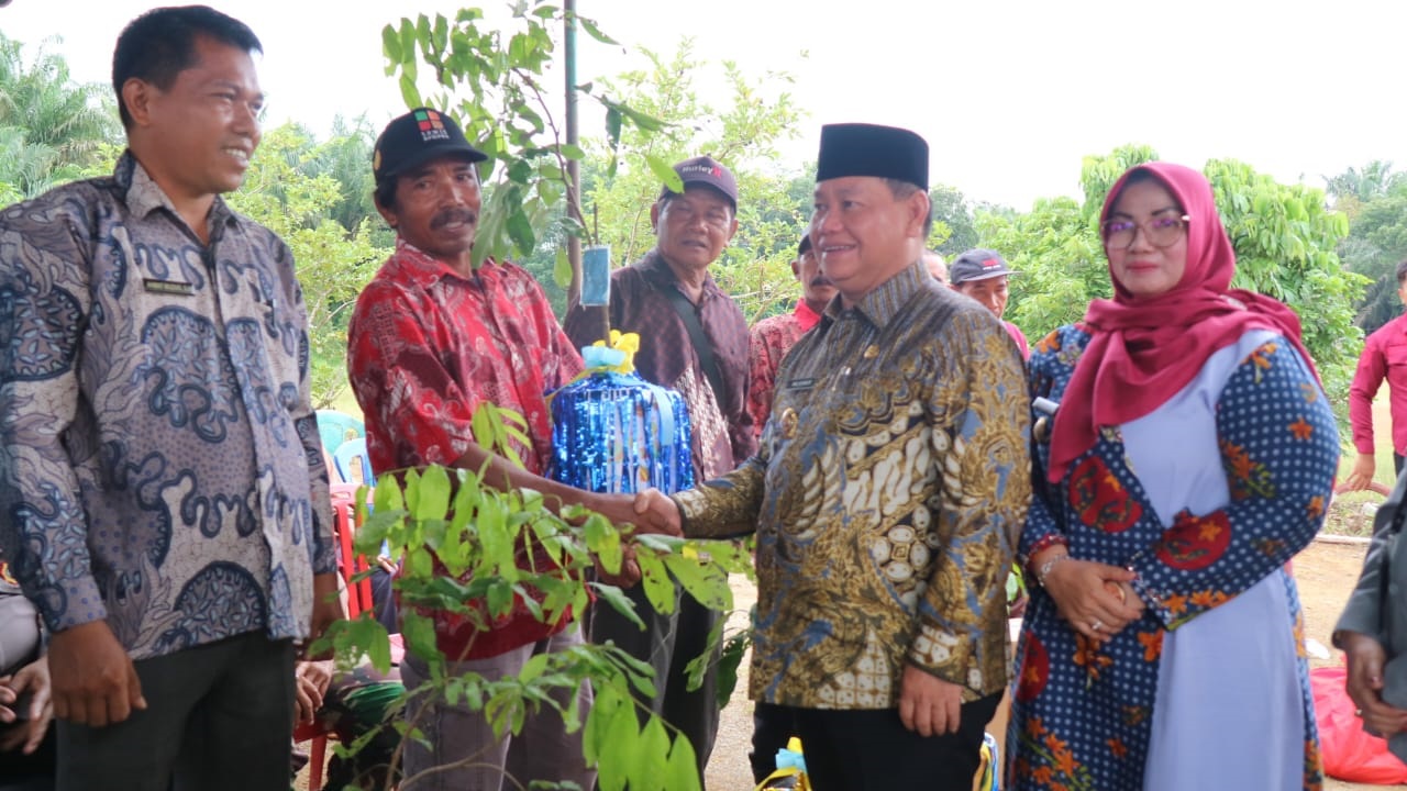 KUNJUNGAN KERJA: Bupati Kotim Halikinnor didampingi Wakil Bupati Kotim Irawati menyerahkan bibit lengkeng kepada Kelompok Tani Jaya Makmur Desa Buana Mustika.&nbsp;(ISTIMEWA/RADAR SAMPIT)