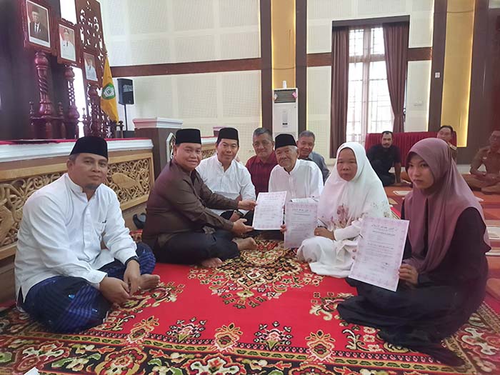 MUALAF: Pasangan lansia Nasrun dan Rusiani (65) asal Desa Parit, bersama cucunya Jeny Zaskia, resmi masuk Islam. (HENY/RADAR SAMPIT)