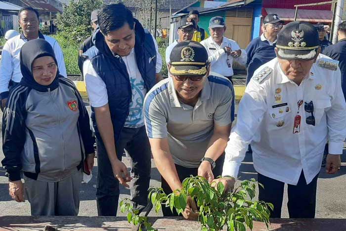 GOTONG ROYONG: Penjabat Bupati Kobar dan Ketua DPRD Kobar melakukan penanaman pohon di water front city, Kelurahan Mendawai, Rabu (26/6).&nbsp;