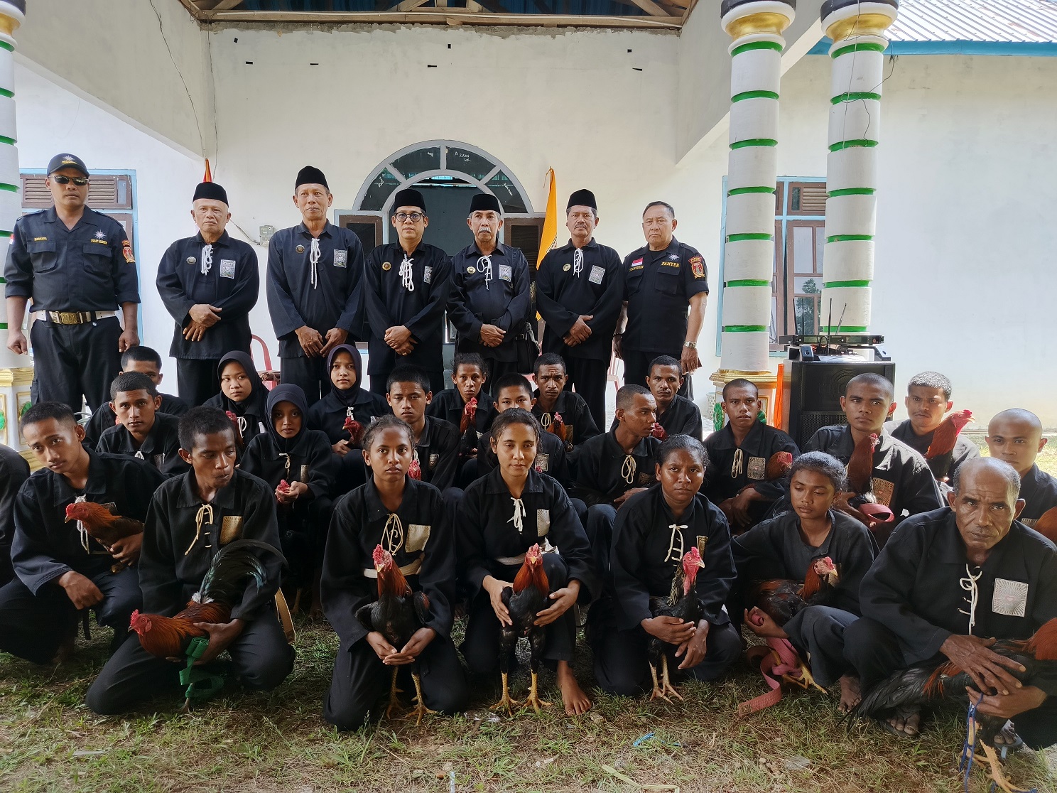 CALON WARGA PSHT: Sejumlah pesilat di Desa Bumi Agung Kecamatan Bulik berbaju hitam tampak menggendong ayam jago menggunakan selembar kain jarik, Senin (22/7).