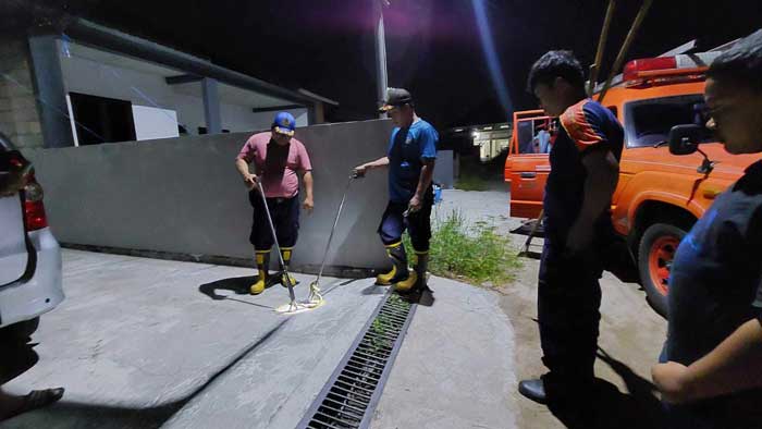 PENANGANAN: Tim Rescue Damkar saat mengevakuasi ular piton sepanjang 1,3 meter di rumah warga Jalan Temanggung Kanyapi III, Palangka Raya. ISTIMEWA/RADAR PALANGKA