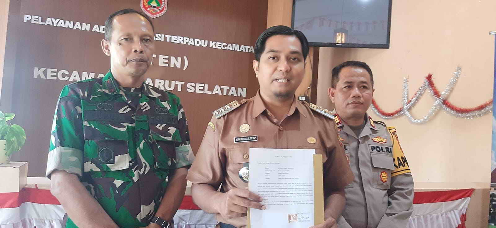 MUNDUR: Camat Arut Selatan Indra Wardhana didampingi Danramil dan Kapolsek Arut Selatan menunjukkan surat pengunduran diri Kades Runtu, Selasa (3/9).