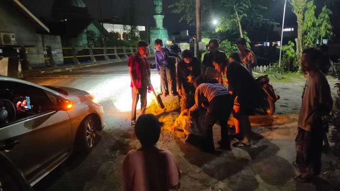 CELAKA: Warga membantu evakuasi bocah naik motor yang mengalami kecelakaan tunggal di Jalan Iskandar, Sampit, Minggu (8/9/24) malam. FAHRY/RADAR SAMPIT
