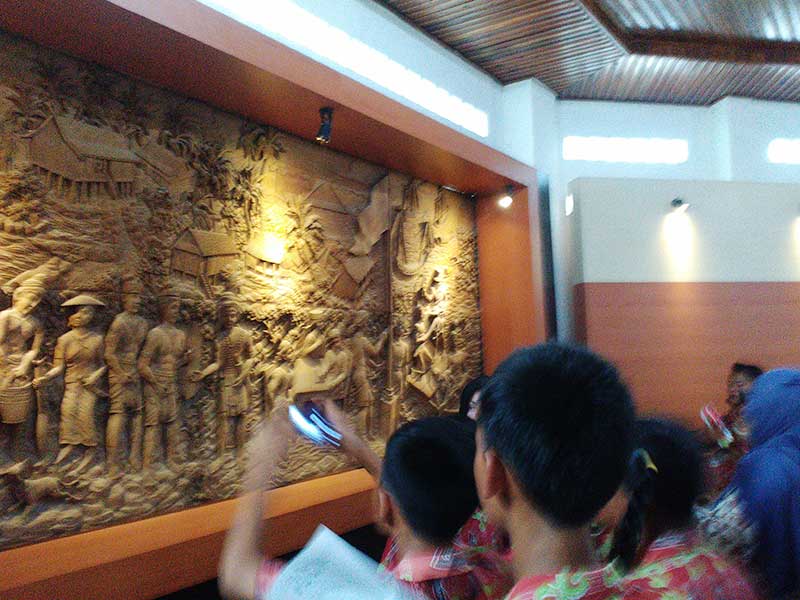 Pengunjung Museum Kayu Sampit, saat memperhatikan salah satu relief terkait budaya asli daerah. (dok.radarsampit)