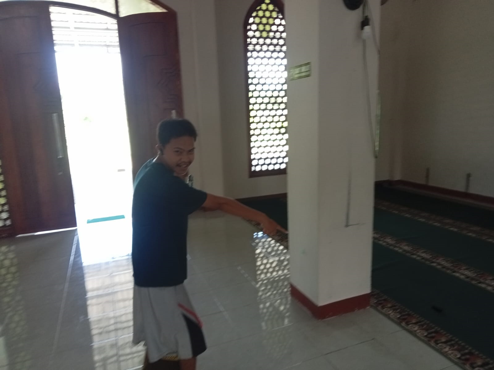 KEHILANGAN: Seorang warga memperlihat kan posisi kotak amal masjid Jalan Desmon Ali, Kecamatan Baamang, Sampit yang diembat pencuri, belum lama ini.