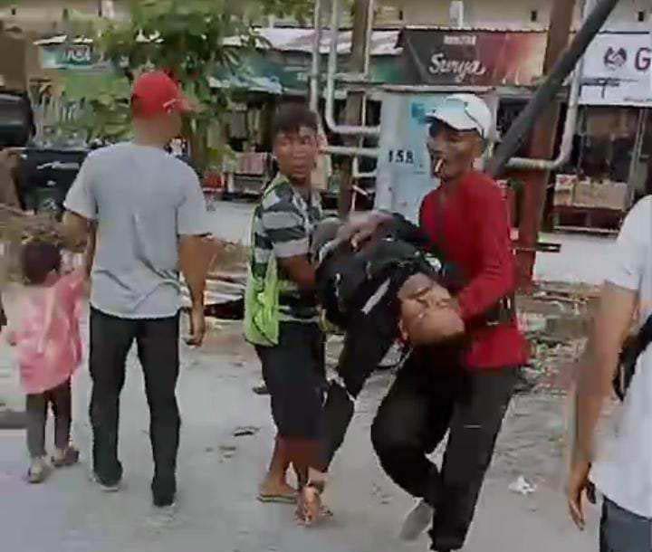 TAK SADARKAN DIRI : Warga saat melakukan evakuasi salah satu pekerja yang tersengat listrik saat pemasangan tiang optik untuk operator seluler di Pasar Kahayan.