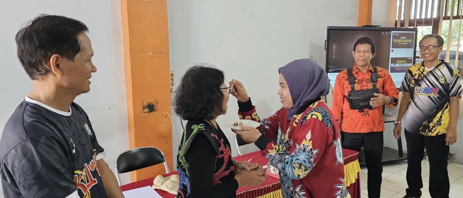 LOYALITAS MENGAJAR: Direktur Radar Sampit Siti Fauziah memberikan potongan kue kepada guru senior, Ibu Endang