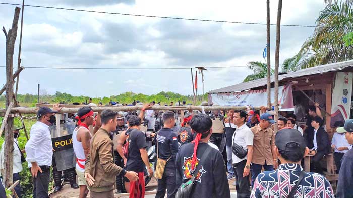AKHIRNYA TEGAS: Tim Kemenag Kalteng dibantu aparat kepolisian membuka portal penghalang di lahan yang akan dibangun Madrasah, Senin (7/10). (DODI/RADAR SAMPIT)