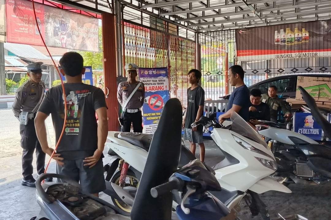 PENERTIBAN: Satlantas Polres Kobar saat memberikan imbauan larangan penggunaan knalpot tidak sesuai spesifikasi teknis di salah satu bengkel di Pangkalan Bun, Jumat (25/10).