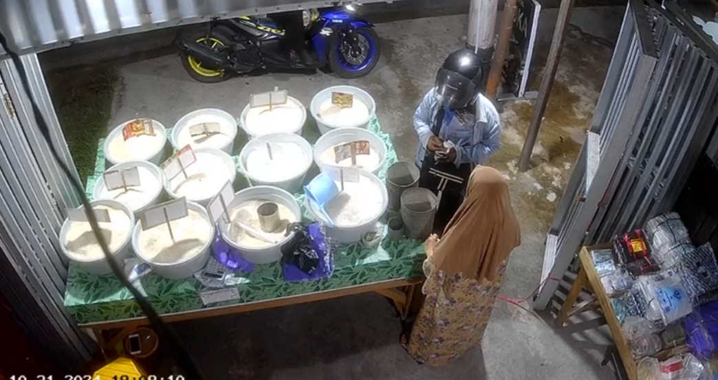 VIRAL: Hasil rekaman CCTV memperlihatkan sosok seorang wanita (pakai jaket dan helm) yang diduga membayar dengan uang palsu ketika membeli beras di Kuala Kapuas, baru-baru tadi.