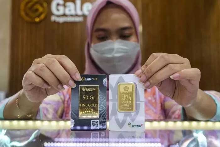 NAIK: Karyawan menunjukan emas Antam yang hari ini harganya naik Rp 14.000 per gram, di salah satu butik. (ANTARA)