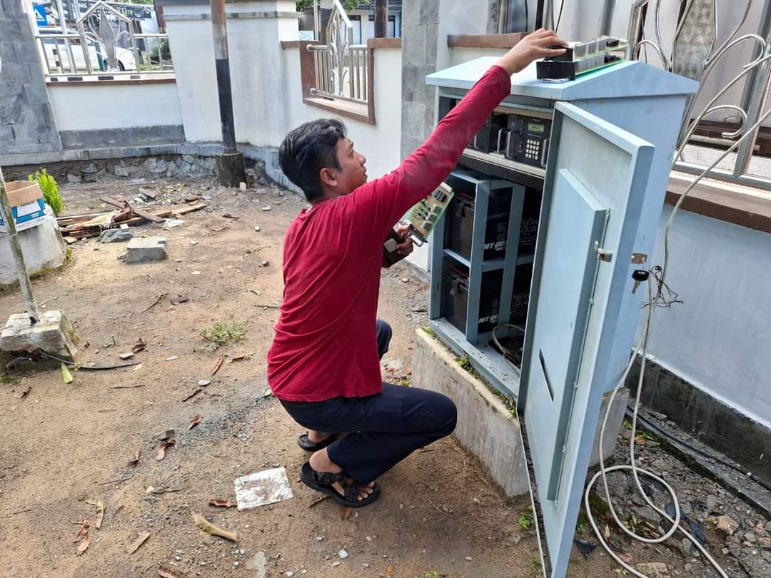 TERDAMPAK PETIR: Teknisi dari Dishub Kobar sedang melakukan perbaikan salah satu unit APILL yang rusak belum lama tadi.