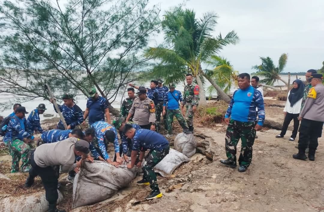 Personel gabungan, dari BPBD Kobar, TNI AD, TNI AU dan Polres Kobar, saat bahu membahu membenahi tanggul dari pasir di Desa Keraya, belum lama tadi.