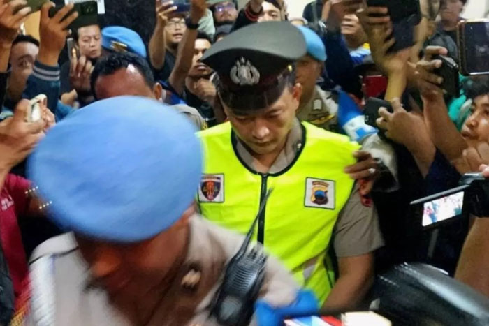 Anggota Polrestabes Semarang Aipda R, terduga pelaku penembakan siswa SMKN 4 Kota Semarang, memasuki ruang sidang Bidang Propam Polda Jawa Tengah di Semarang, Senin (9/12). (I.C. Senjaya/Antara)
