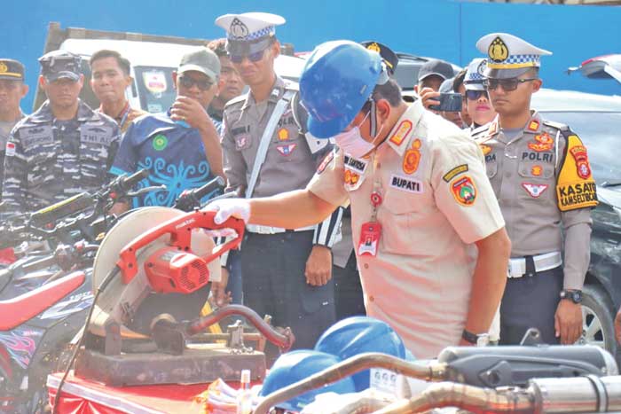TINDAK TEGAS: Pj Bupati Kobar Budi Santosa dan jajaran anggota kepolisian Polres Kobar saat memotong knalpot brong dengan mesin gerinda, dari hasil razia satlantas Polres Kobar.