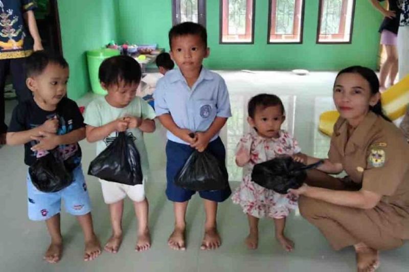 Perangkat Desa Tumbang Tariak di Kabupaten Gumas ketika menyalurkan PMT yang dianggarkan dari APBDes 2024, belum lama ini.