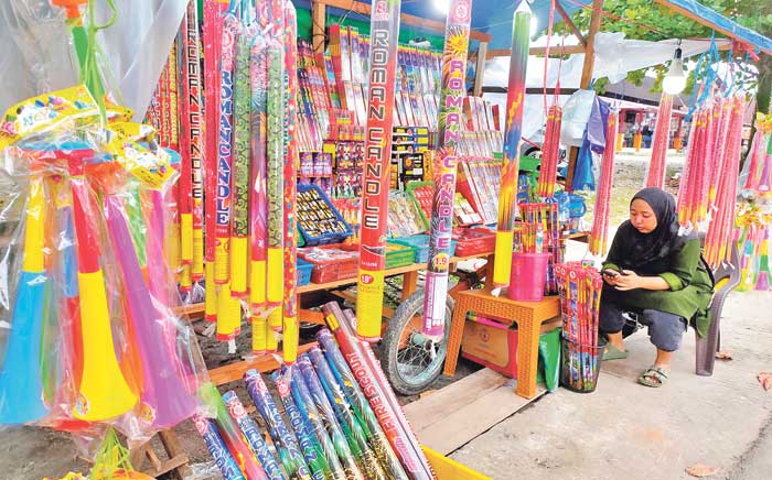 TETAP OPTIMIS: Penjualan terompet dan kembang api di Taman Kota Sampit tampak masih sepi pembeli, Sabtu (28/12).
