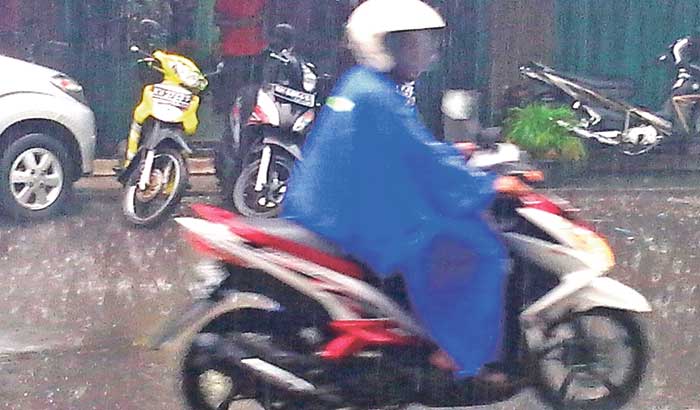 MUSIM HUJAN: Salah satu pengendara saat melaju di tengah hujan yang mengguyur Kota Sampit.