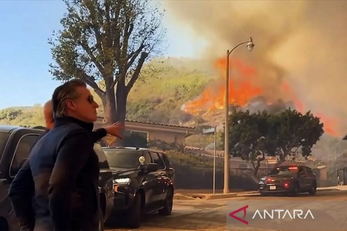 Sejumlah warga mengamati api yang melahap hutan dan lahan di Los Angeles, California, Kamis (9/1/2025). ANTARA/Anadolu/as/am.