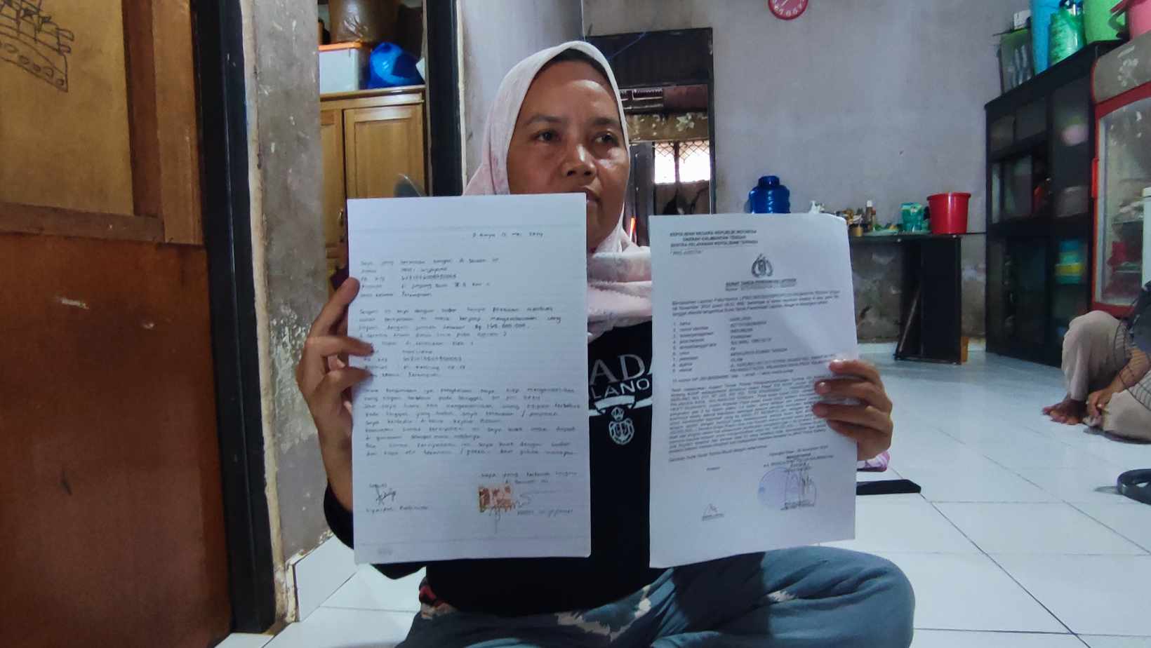 BUKTI: Korban Marliana saat memperlihatkan laporan dan barang bukti perjanjian bersama terlapor,&nbsp;oknum Bhayangkari berinisial HW. DODI/RADAR SAMPIT