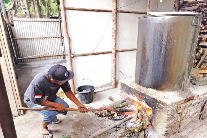 MENUAI HASIL: Proses produksi air rebusan di kediaman Bagol yang akan dijual pada pelanggannya.