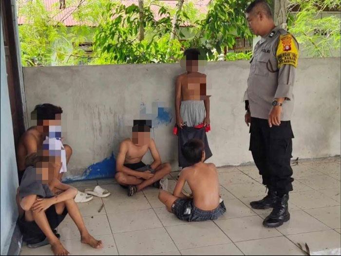 Petugas Polsek Pahandut saat memergoki lima anak masih di bawah umur saat menghirup aroma lem berbahan kimia di belakang posyandu, di Kelurahan Kalampangan.