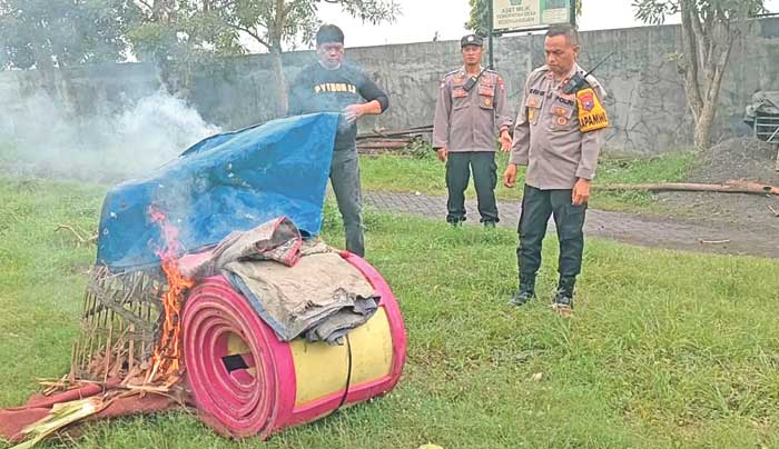 DIBAKAR: Sejumlah alat judi sabung ayam di TPST Desa Sedenganmijen, Krian, Sidoarjo diamankan dan beberapa di antaranya dimusnahkan polisi, Senin (27/1). (DIKY PUTRA SANSIRI/RADAR SIDOARJO)