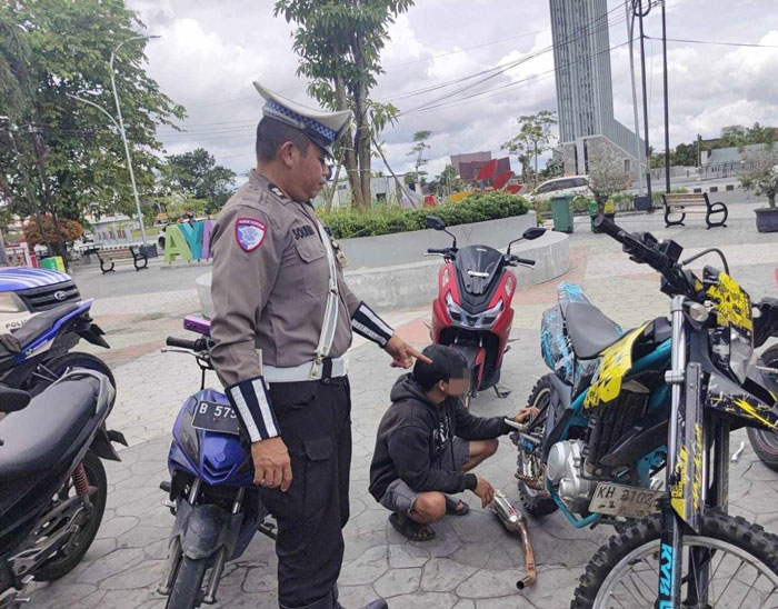 PENINDAKAN : Petugas Satlantas Polresta Palangka Raya meminta pengendara motor untuk melepas knalpot brong. ISTIMEWA/RADAR PALANGKA